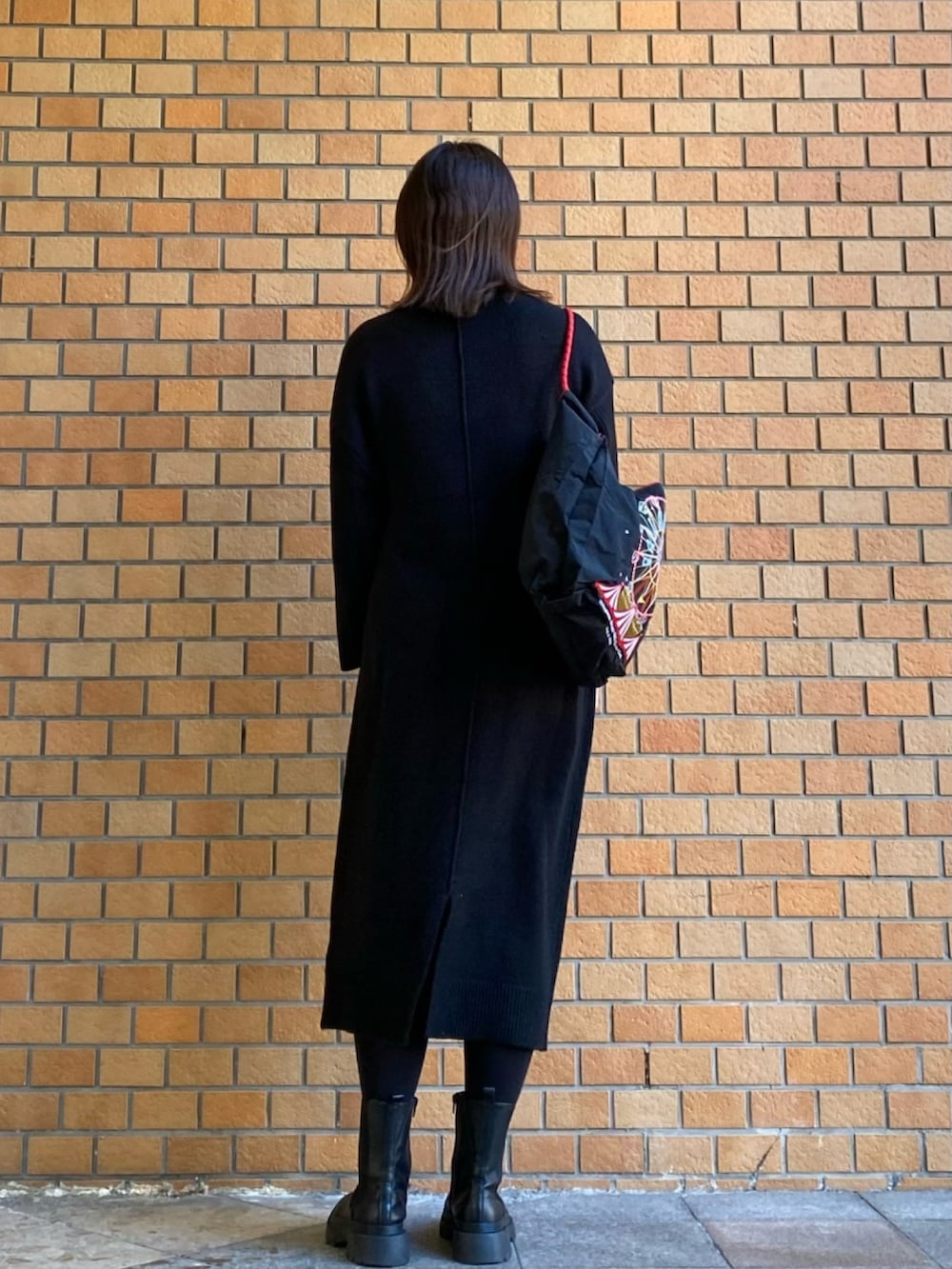 ブラック系のワンピース、ブラック系のトートバッグを着用したレディースの冬コーディネートの3枚目の写真