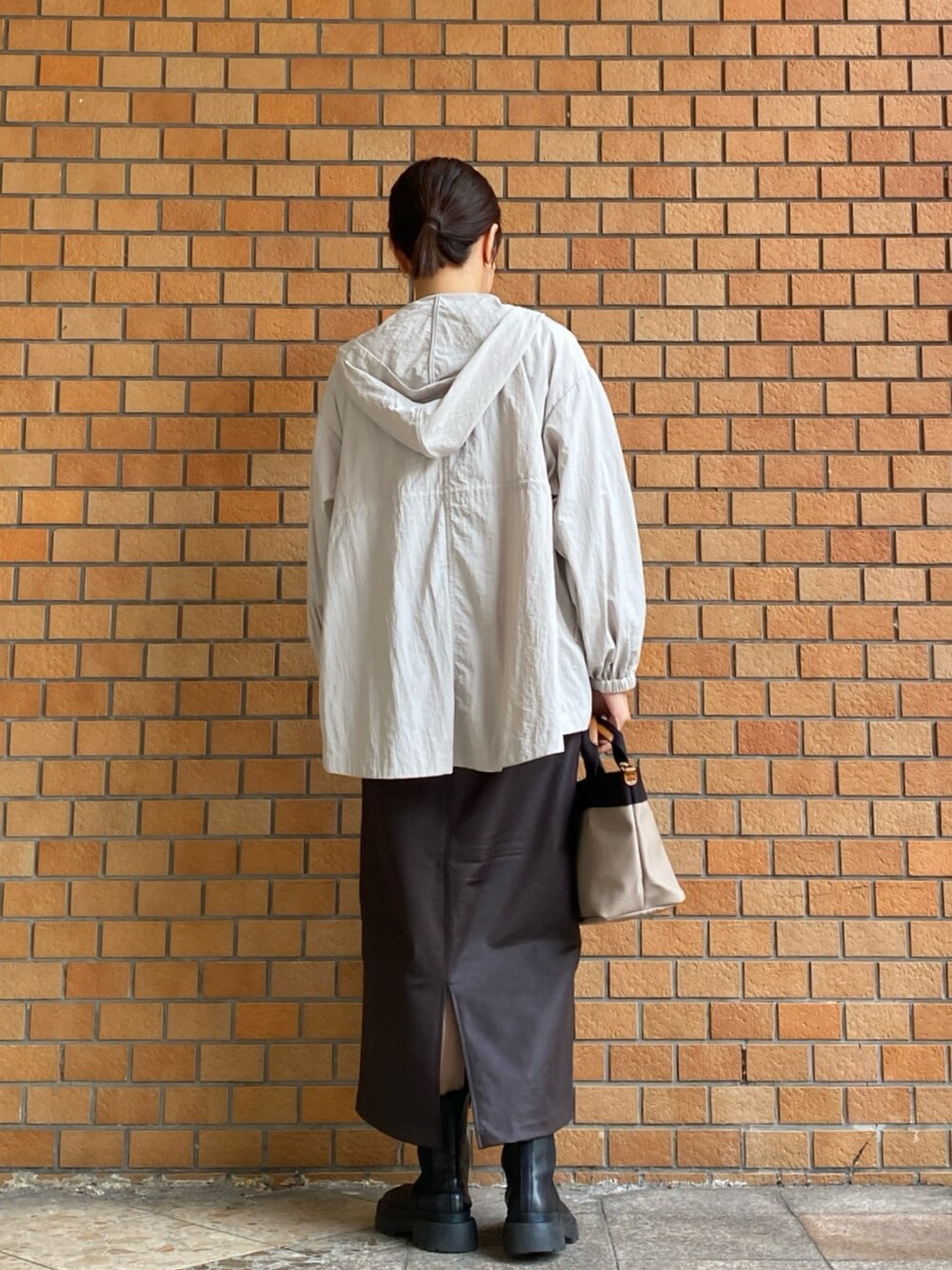 ブルー系のTシャツ/カットソー、ブラウン系のスカート、ベージュ系のマウンテンパーカーを着用したレディースの秋コーディネートの6枚目の写真