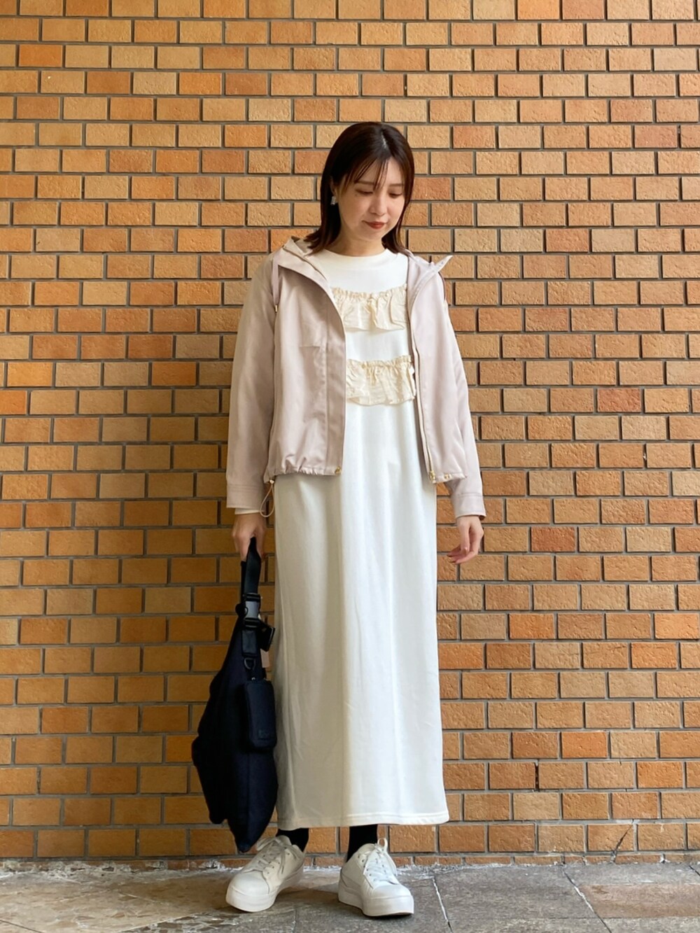 ベージュ系のマウンテンパーカー、ホワイト系のワンピースを着用したレディースの冬コーディネートの2枚目の写真