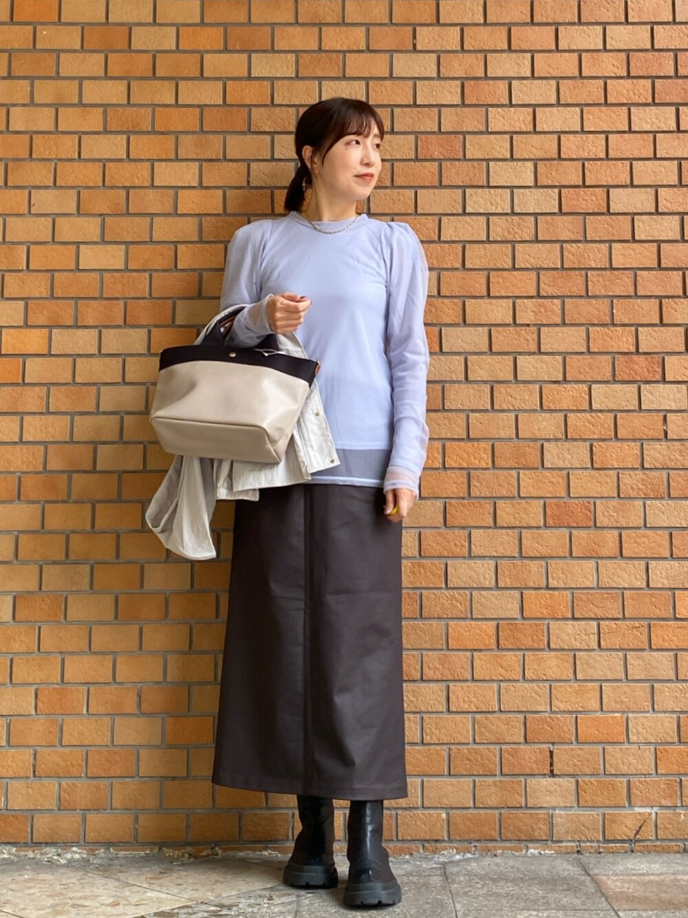 ブルー系のTシャツ/カットソー、ブラウン系のスカート、ベージュ系のマウンテンパーカーを着用したレディースの秋コーディネートの3枚目の写真