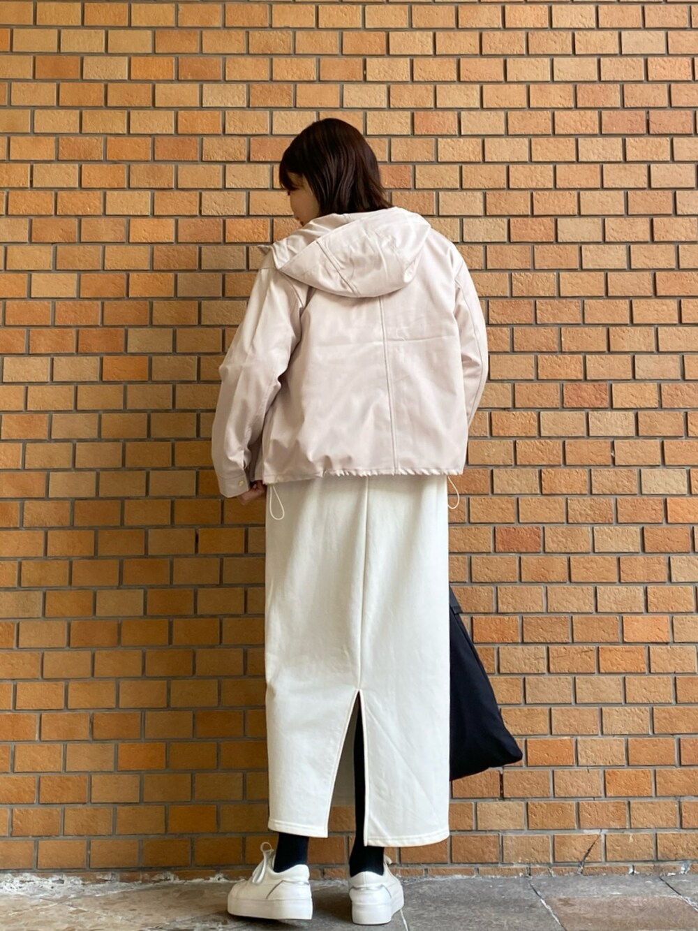 ベージュ系のマウンテンパーカー、ホワイト系のワンピースを着用したレディースの冬コーディネートの4枚目の写真