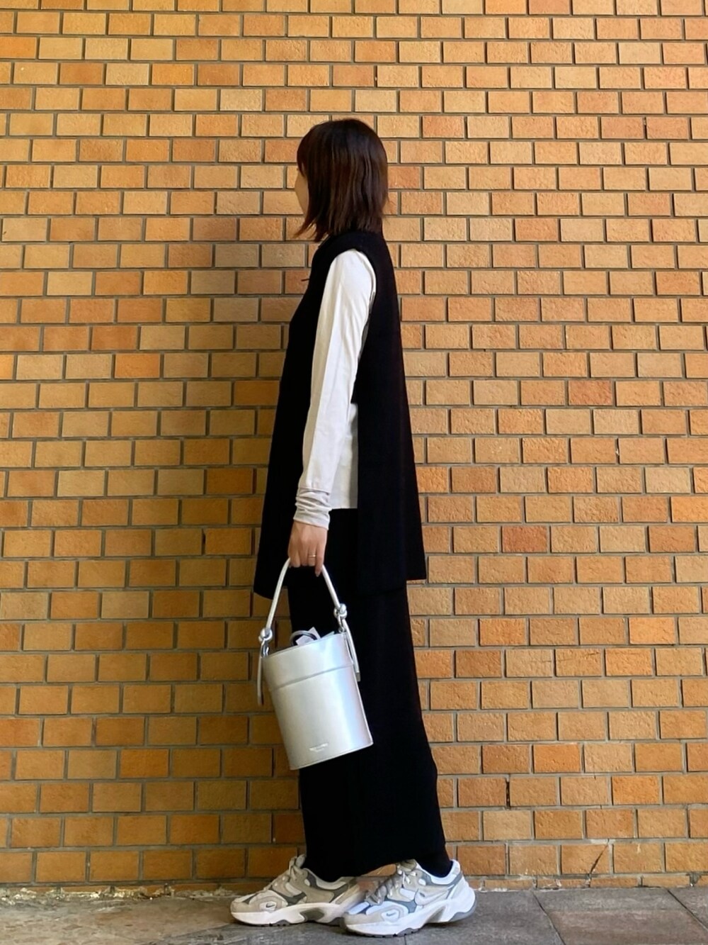 ブラック系のワンピース、ホワイト系のTシャツ/カットソー、シルバー系のショルダーバッグを着用したレディースの秋コーディネートの3枚目の写真