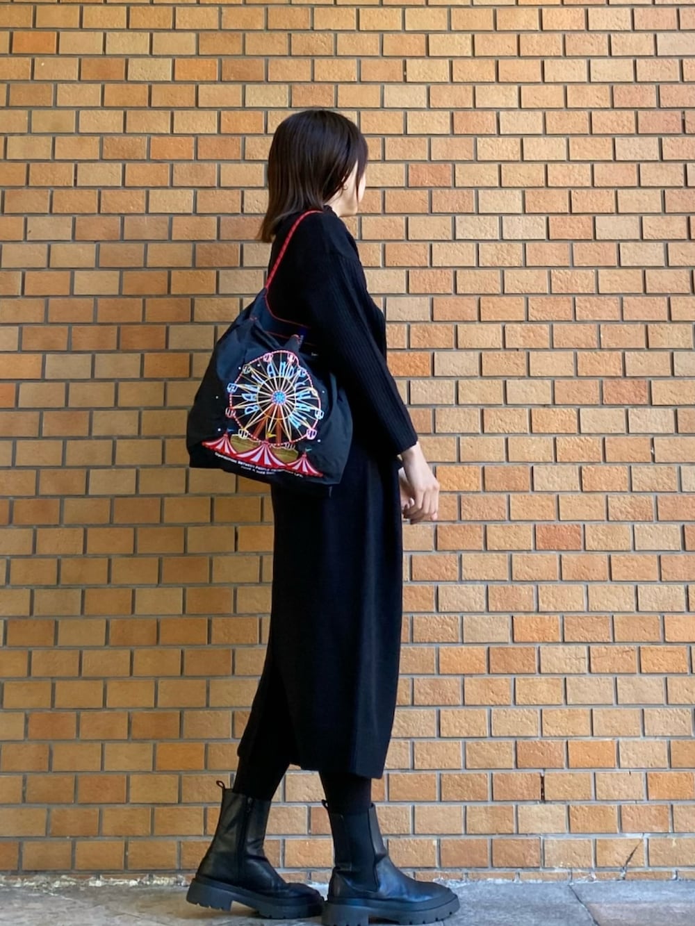 ブラック系のワンピース、ブラック系のトートバッグを着用したレディースの冬コーディネートの2枚目の写真