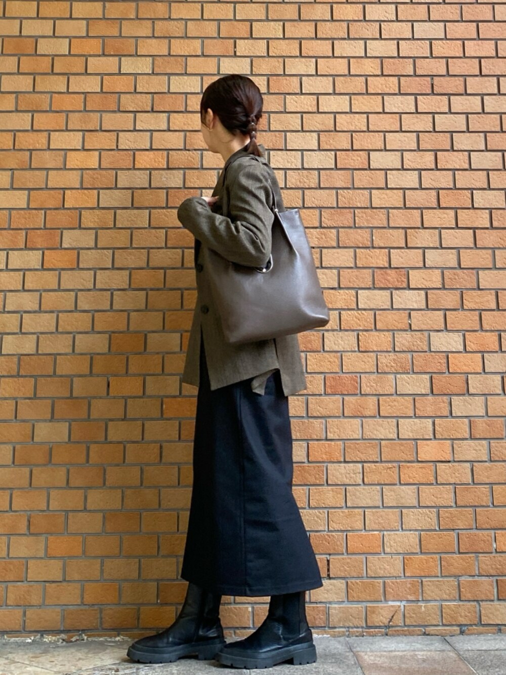 ベージュ系のテーラードジャケット、ホワイト系のニット/セーター、ブラック系のスカートを着用したレディースの秋コーディネートの2枚目の写真