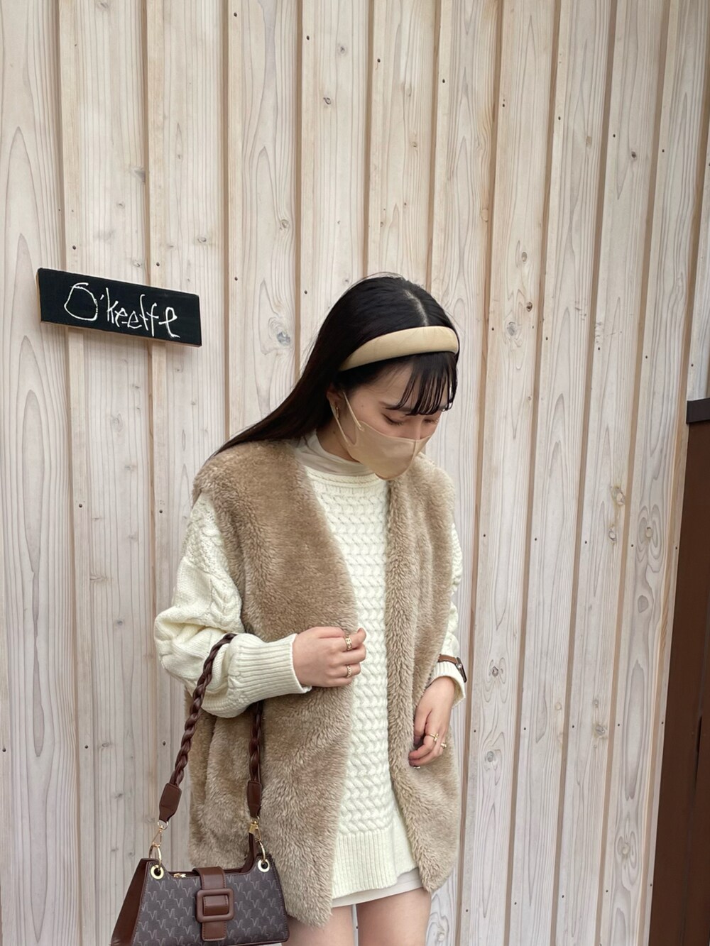 ベージュ系のトップスを着用したレディースの春コーディネートの2枚目の写真