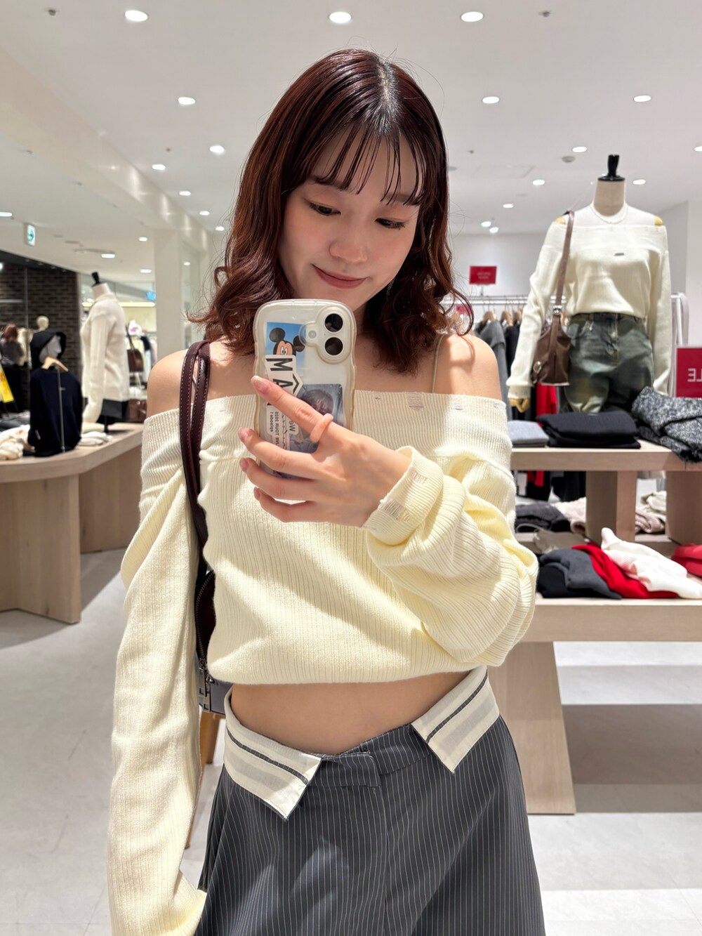 ホワイト系のニット/セーター、グレー系のその他パンツ、イエロー系のボストンバッグを着用したレディースの冬コーディネートの2枚目の写真