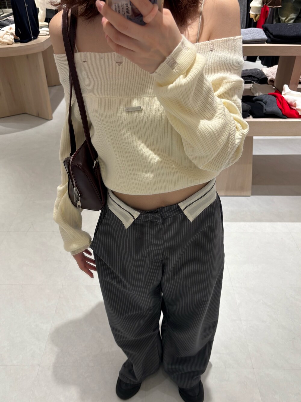 ホワイト系のニット/セーター、グレー系のその他パンツ、イエロー系のボストンバッグを着用したレディースの冬コーディネートの3枚目の写真