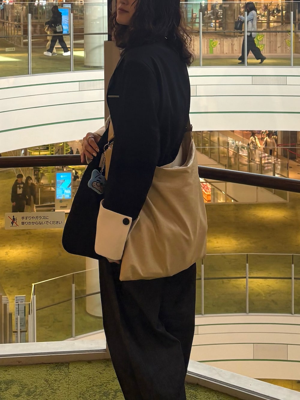 ブルー系のデニムパンツ、ブラウン系のブーツ、ホワイト系のキャミソールを着用したレディースの春コーディネートの3枚目の写真