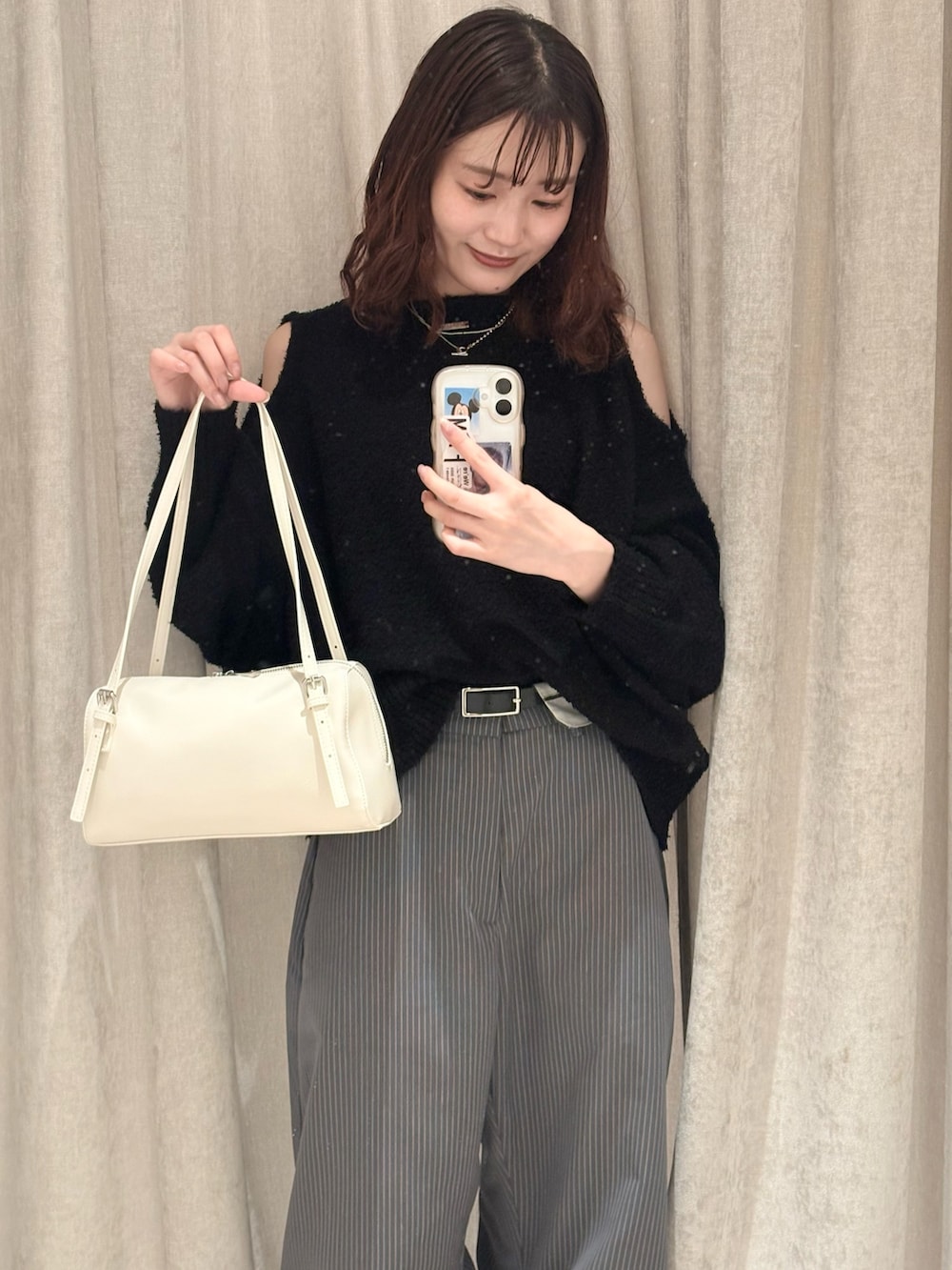 ブラック系のニット/セーター、グレー系のその他パンツ、ホワイト系のボストンバッグを着用したレディースの冬コーディネートの2枚目の写真