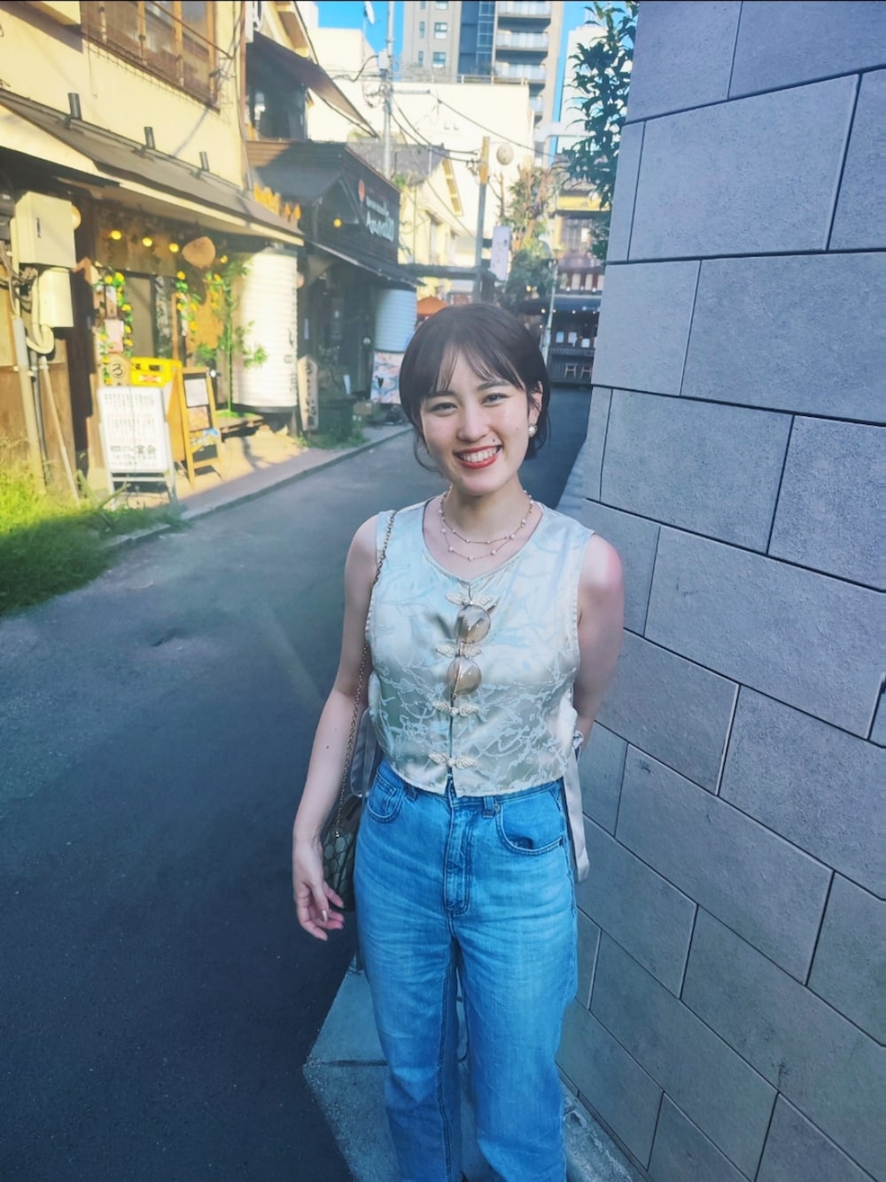 シルバー系のTシャツ/カットソー、ブルー系のデニムパンツを着用したレディースの夏コーディネートの2枚目の写真