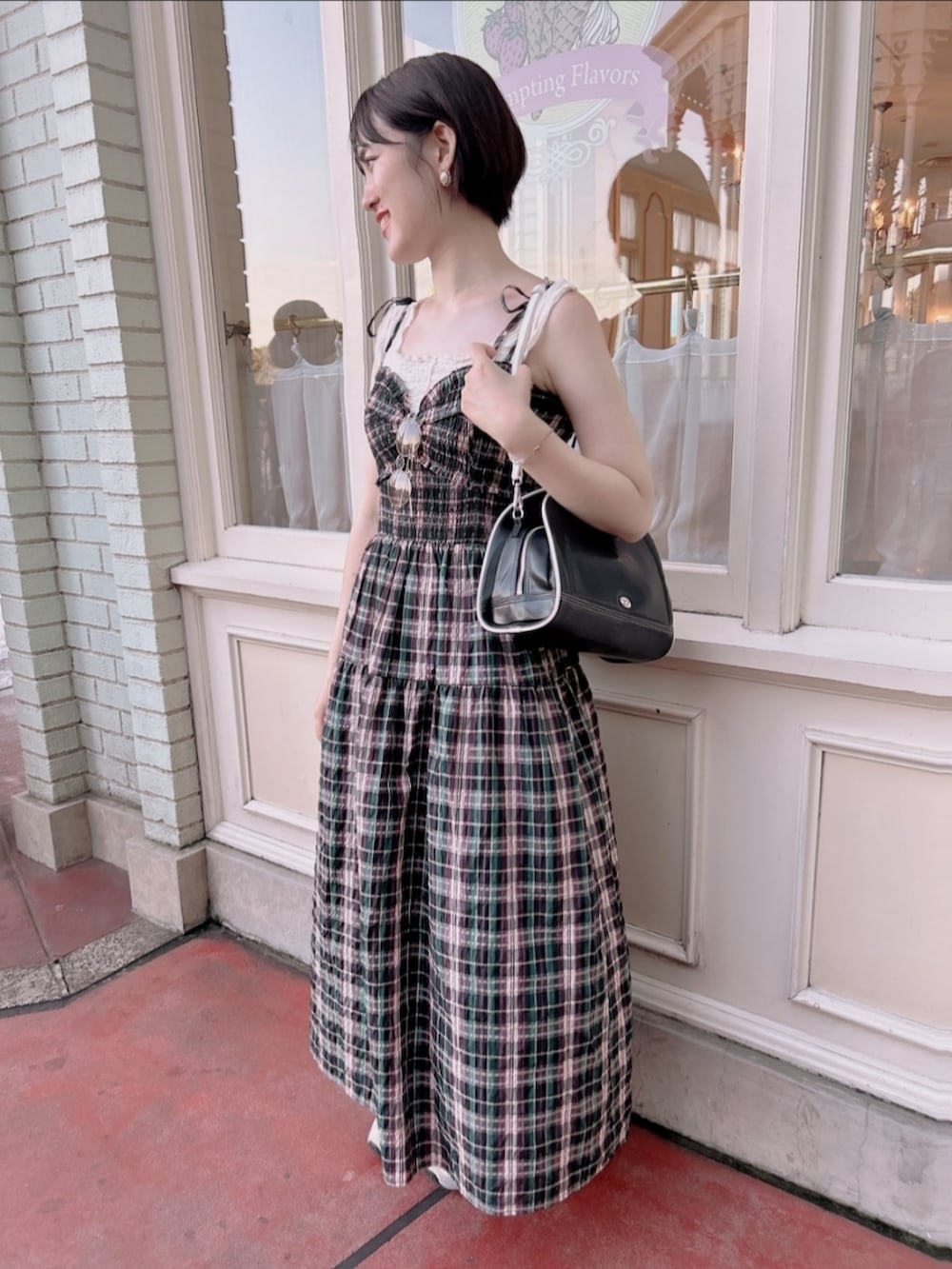 ホワイト系のスニーカー、ブラック系のハンドバッグ、その他のワンピースを着用したレディースの夏コーディネートの2枚目の写真