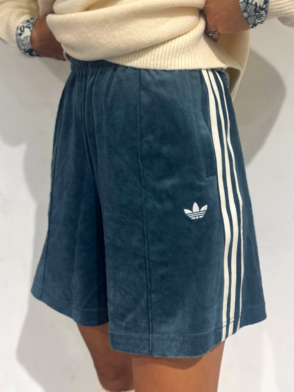 グリーン系のその他パンツ、ホワイト系のニット/セーター、ホワイト系のスニーカーを着用したレディースの秋コーディネートの3枚目の写真