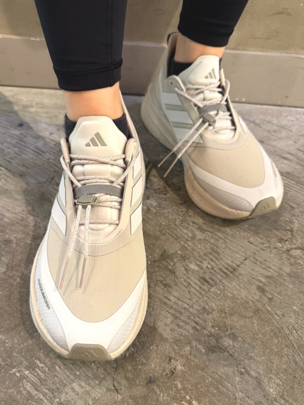 ベージュ系のトップス、ブラック系のパンツ、ベージュ系のシューズを着用したレディースの夏コーディネートの2枚目の写真