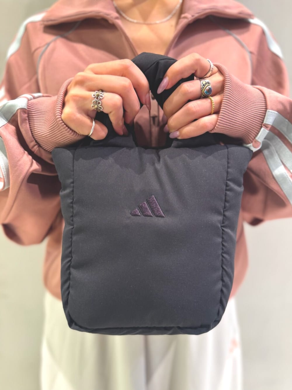 レッド系のジャージ、ホワイト系のスカート、ブラック系のショルダーバッグを着用したレディースの秋コーディネートの6枚目の写真