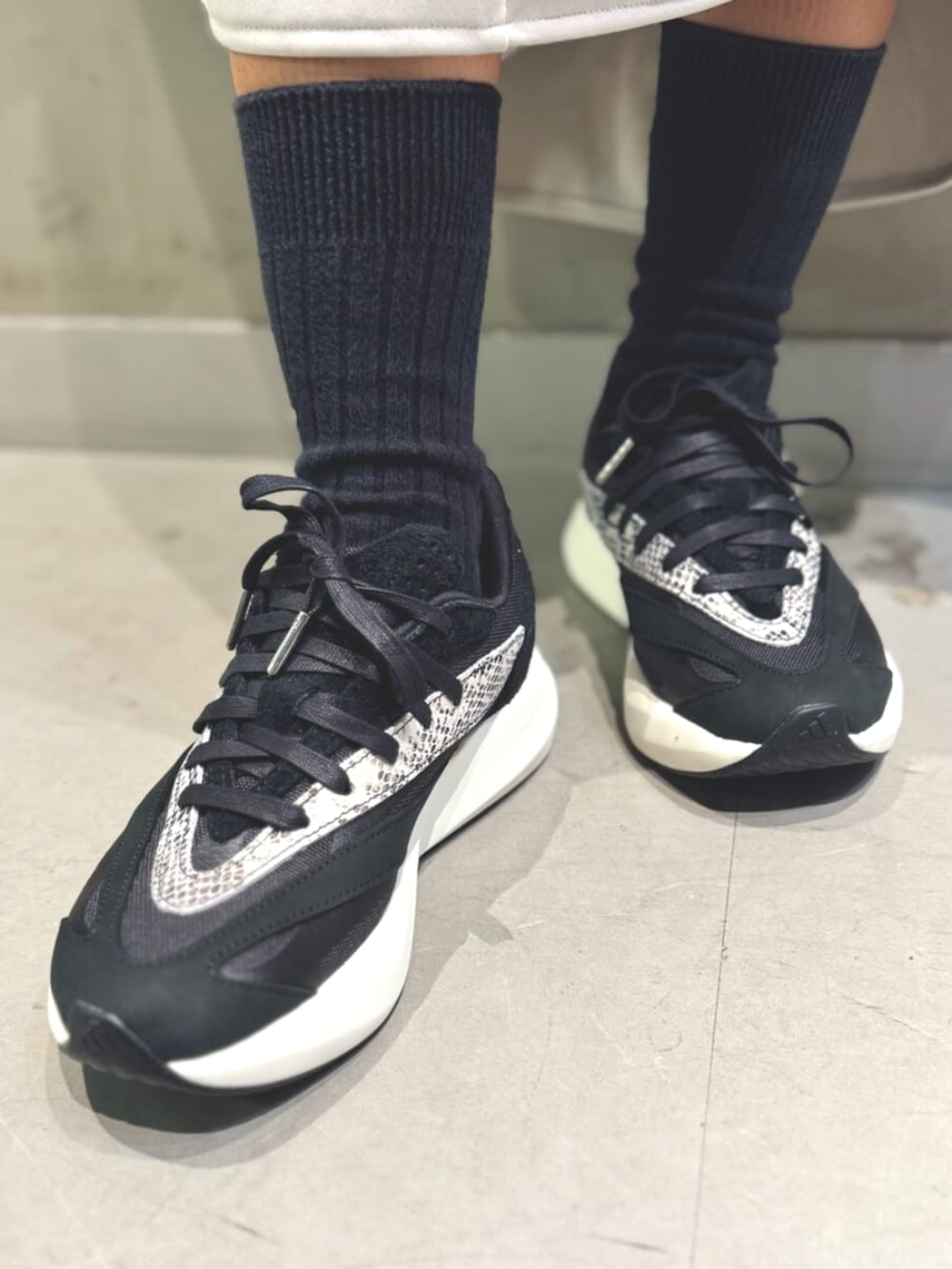 レッド系のジャージ、ホワイト系のスカート、ブラック系のショルダーバッグを着用したレディースの秋コーディネートの5枚目の写真