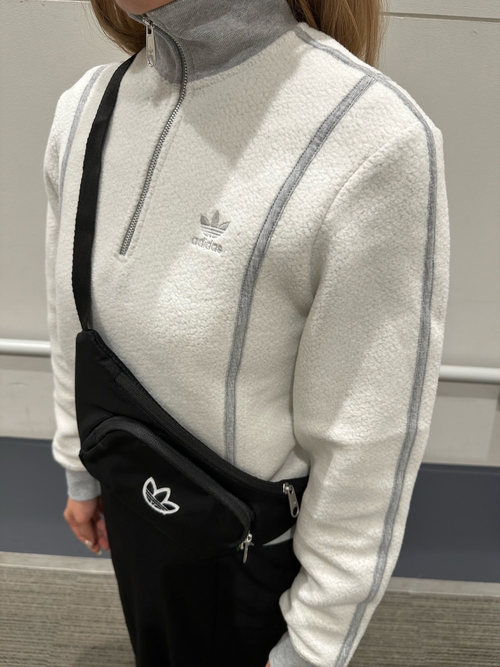 グレー系のスニーカー、ブラック系のボディバッグ/ウエストポーチ、グレー系のブルゾンを着用したレディースの秋コーディネートの4枚目の写真