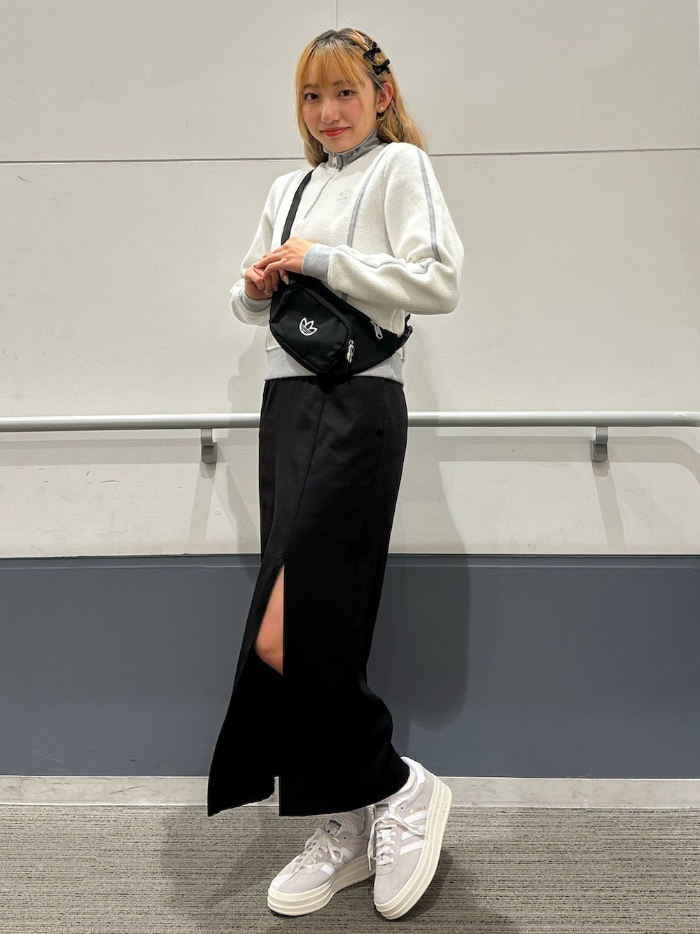 グレー系のスニーカー、ブラック系のボディバッグ/ウエストポーチ、グレー系のブルゾンを着用したレディースの秋コーディネートの3枚目の写真