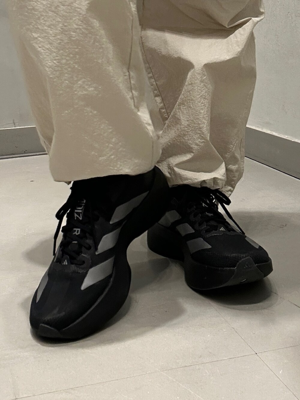 ブラック系のスニーカー、ベージュ系のその他アウター、ベージュ系のその他パンツを着用したレディースの冬コーディネートの6枚目の写真