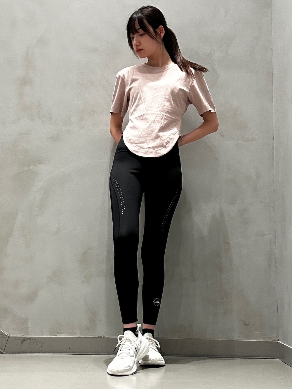 ピンク系のTシャツ/カットソー、グリーン系のバッグ、ホワイト系のスニーカーを着用したレディースの冬コーディネートの2枚目の写真