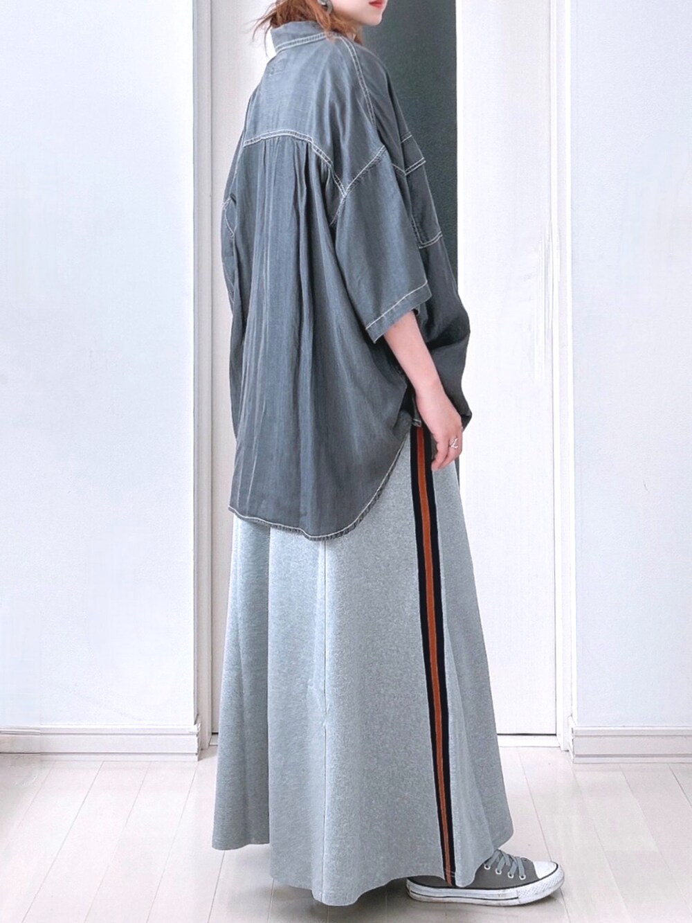 グレー系のスカート、ブラック系のTシャツ/カットソー、ブラック系のシャツ/ブラウスを着用したレディースの秋コーディネートの2枚目の写真