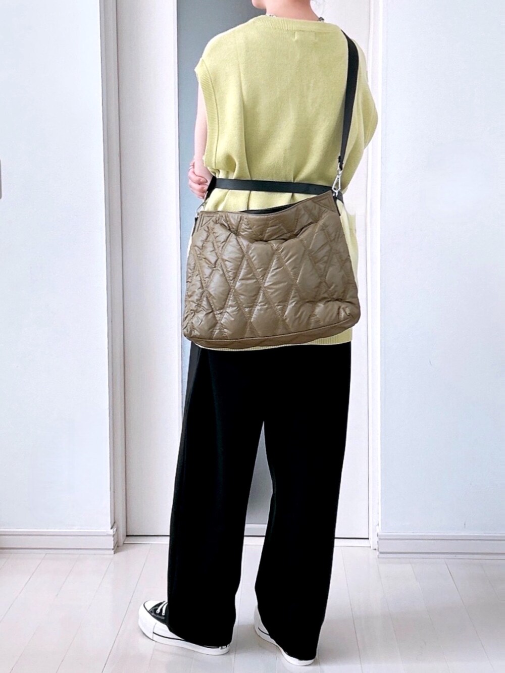 グリーン系のベスト、ブラック系のその他パンツ、グリーン系のボストンバッグを着用したレディースの夏コーディネートの2枚目の写真