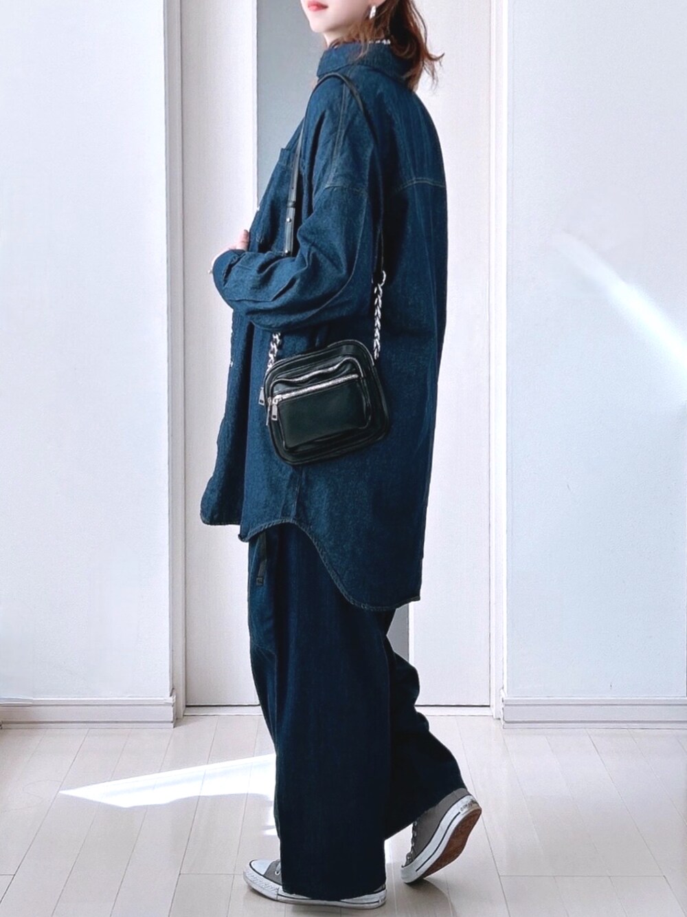 ブルー系のシャツ/ブラウス、ブルー系のデニムパンツ、グレー系のスニーカーを着用したレディースの秋コーディネートの2枚目の写真