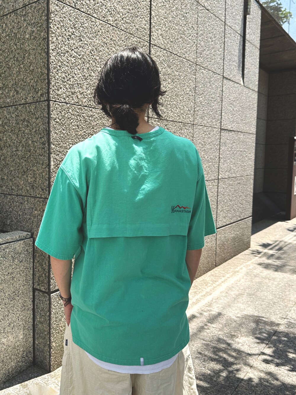 グリーン系のTシャツ/カットソー、ベージュ系のその他パンツ、ブラック系のサンダルを着用したメンズの夏コーディネートの3枚目の写真