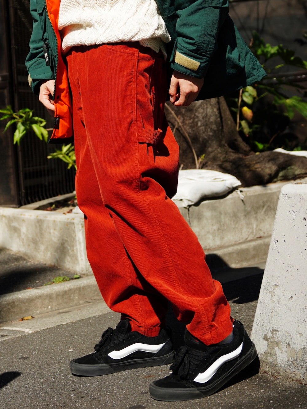 グリーン系のマウンテンパーカー、ホワイト系のニット/セーター、オレンジ系のその他パンツを着用したメンズの秋コーディネートの3枚目の写真