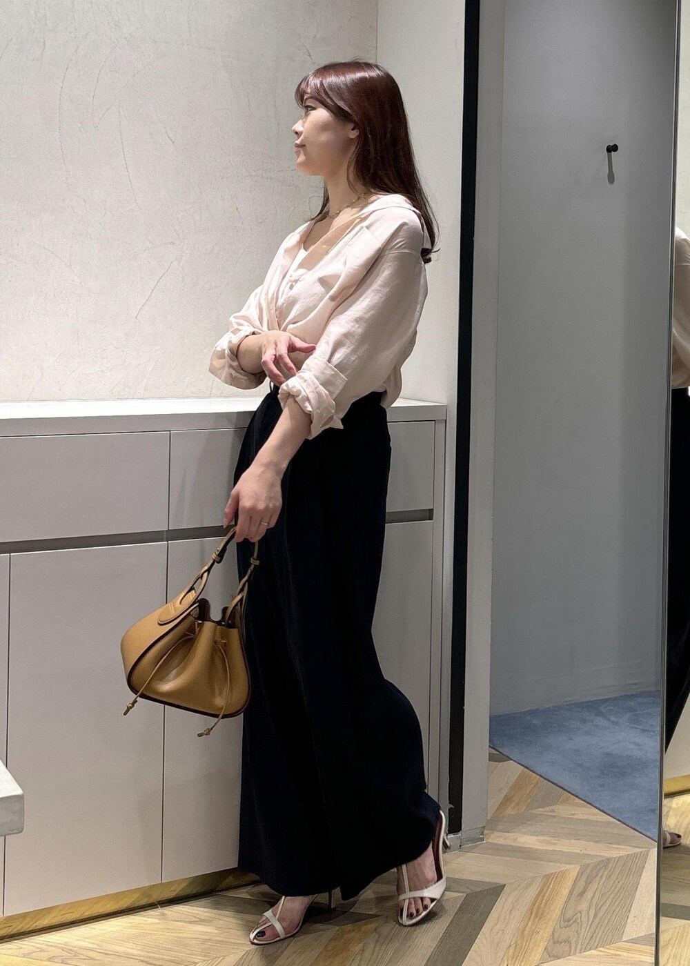 イエロー系のハンドバッグ、ホワイト系のサンダル、ホワイト系のタンクトップを着用したレディースの夏コーディネートの2枚目の写真