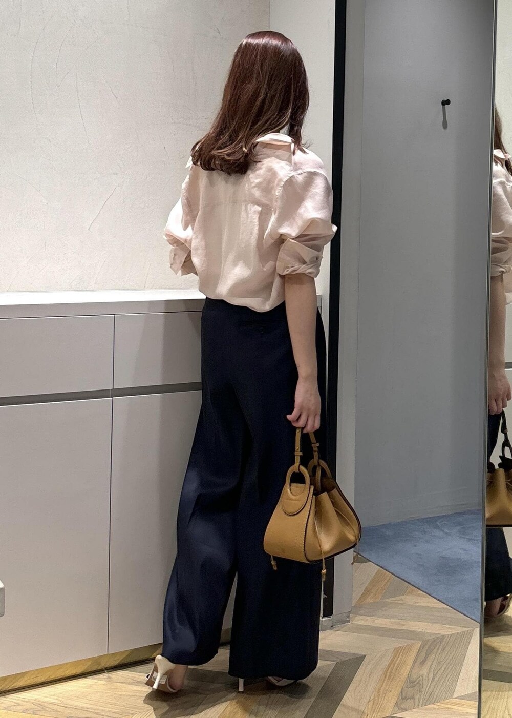 イエロー系のハンドバッグ、ホワイト系のサンダル、ホワイト系のタンクトップを着用したレディースの夏コーディネートの3枚目の写真