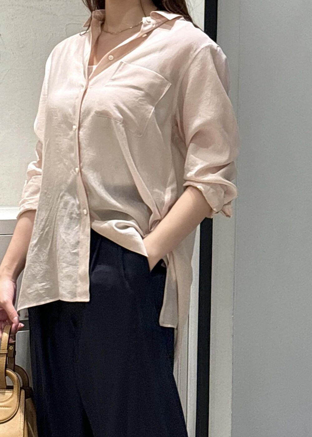 イエロー系のハンドバッグ、ホワイト系のサンダル、ホワイト系のタンクトップを着用したレディースの夏コーディネートの4枚目の写真