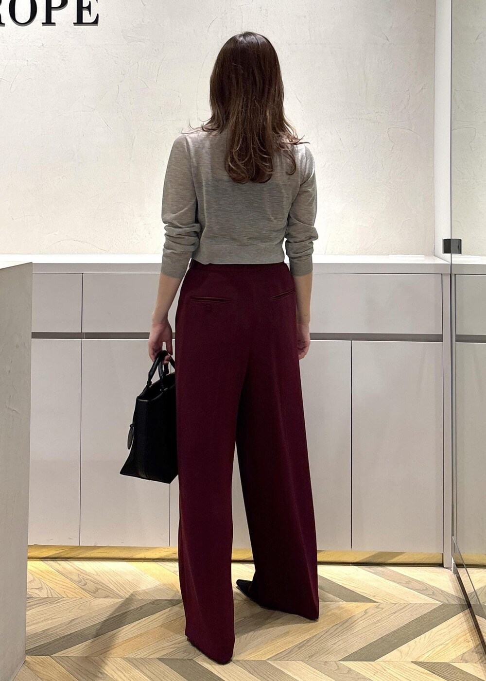 ブラック系のパンプス、レッド系のその他パンツ、ベージュ系のカーディガン/ボレロを着用したレディースの夏コーディネートの4枚目の写真