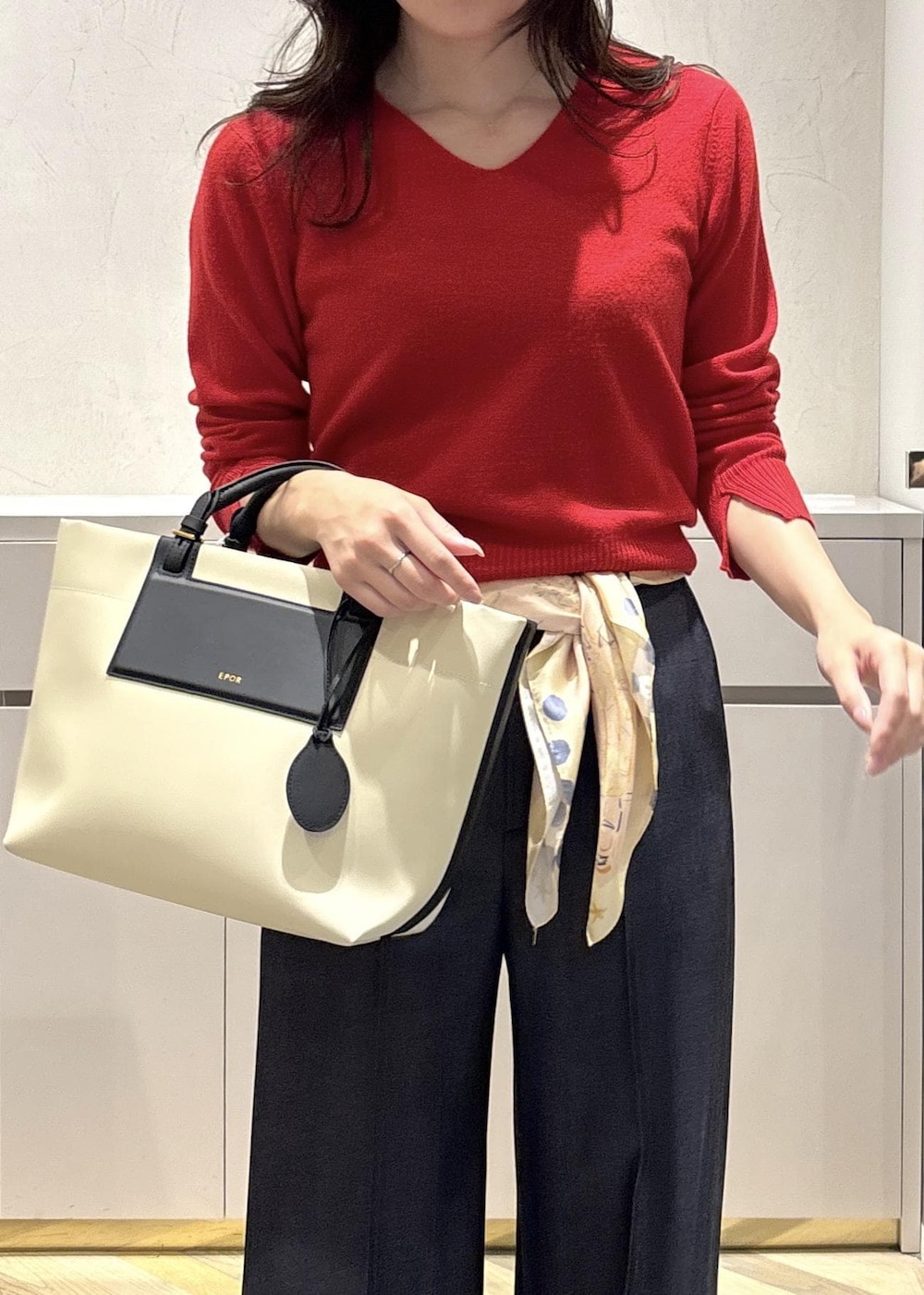 ホワイト系のトートバッグ、ブラック系のブーツ、ブルー系のその他パンツを着用したレディースの冬コーディネートの4枚目の写真