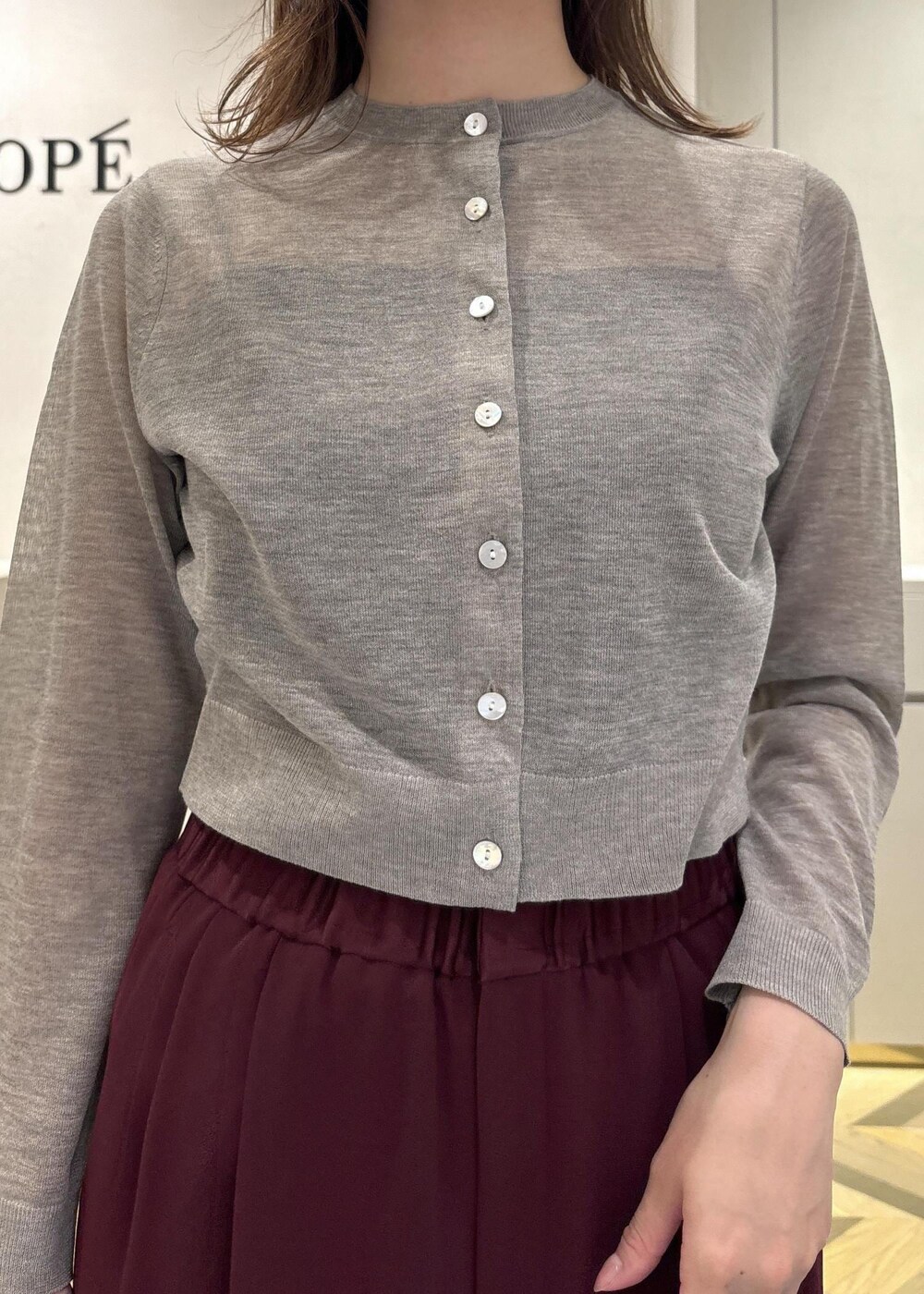 ブラック系のパンプス、レッド系のその他パンツ、ベージュ系のカーディガン/ボレロを着用したレディースの夏コーディネートの7枚目の写真