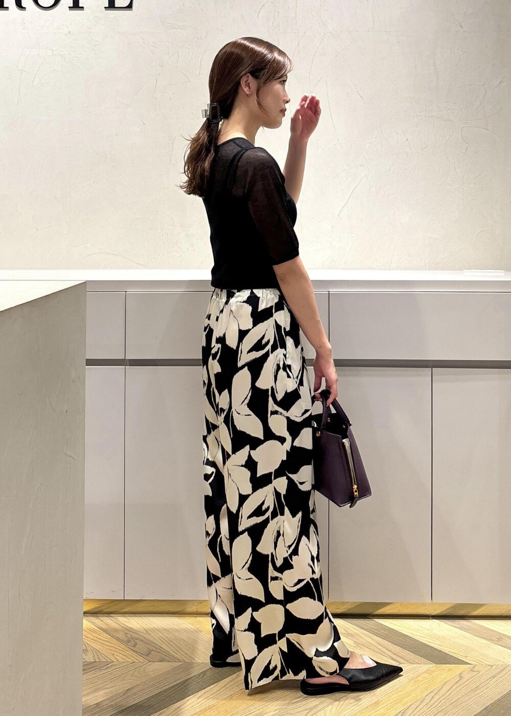 ブラック系のパンプス、ブラック系のニット/セーター、ブラック系のその他パンツを着用したレディースの夏コーディネートの2枚目の写真