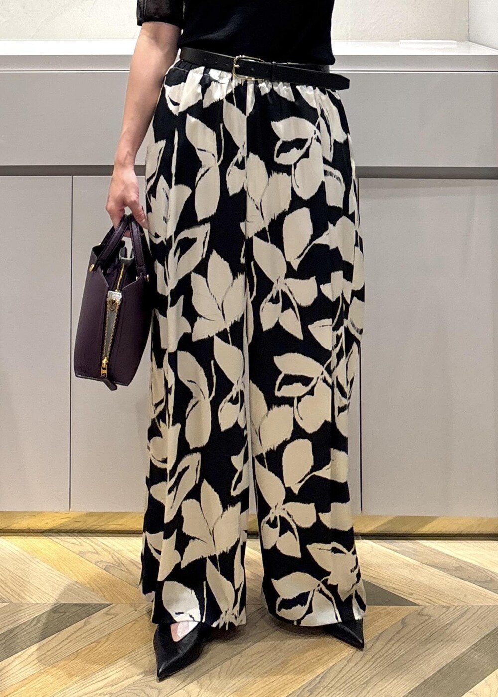 ブラック系のパンプス、ブラック系のニット/セーター、ブラック系のその他パンツを着用したレディースの夏コーディネートの7枚目の写真