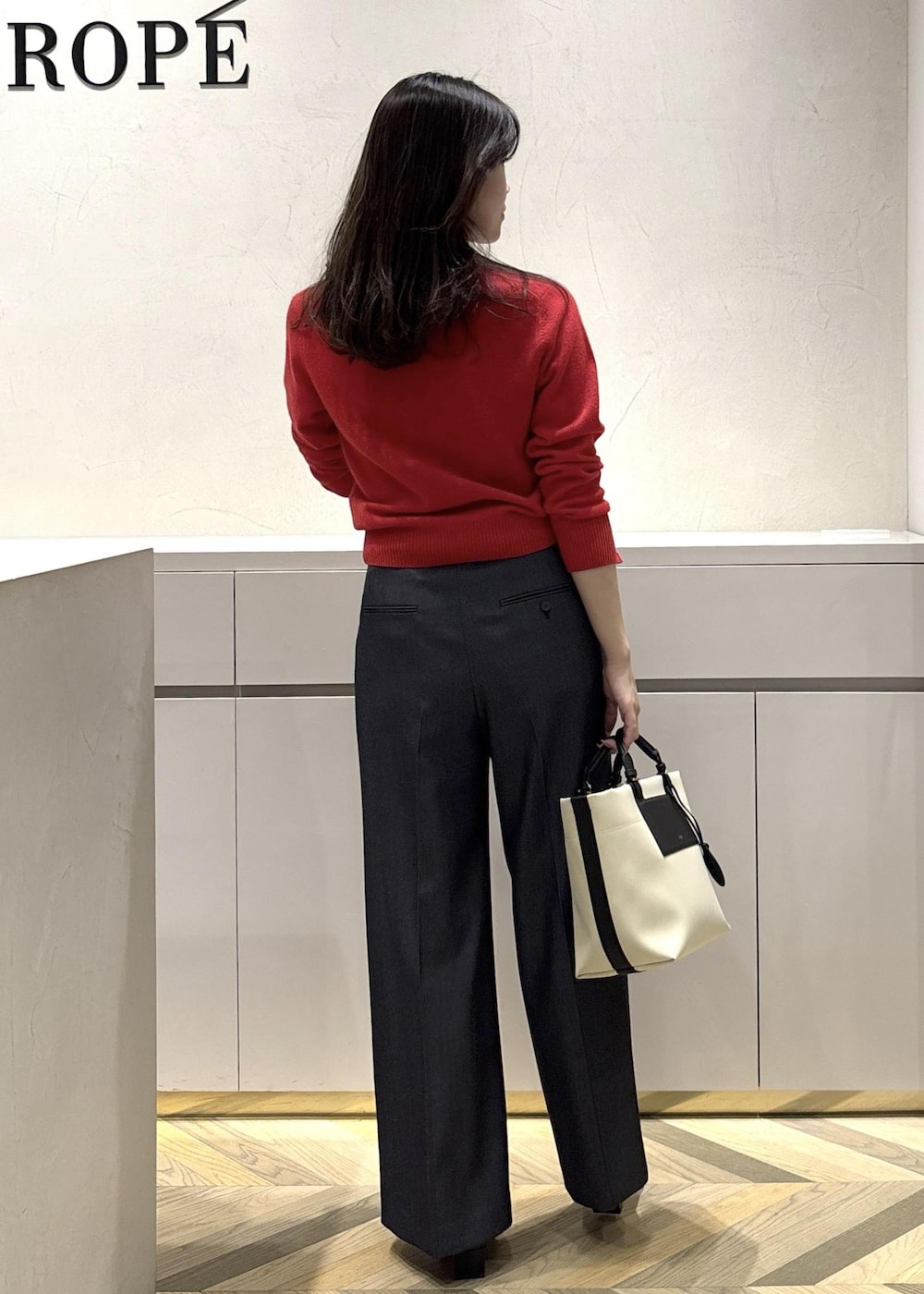 ホワイト系のトートバッグ、ブラック系のブーツ、ブルー系のその他パンツを着用したレディースの冬コーディネートの3枚目の写真