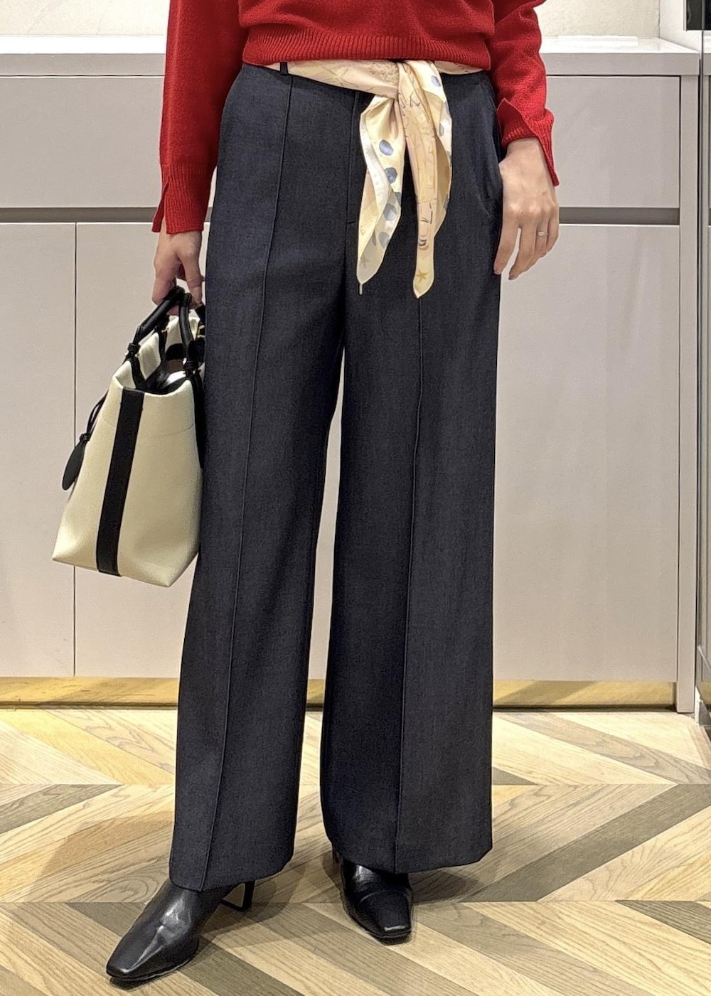 ホワイト系のトートバッグ、ブラック系のブーツ、ブルー系のその他パンツを着用したレディースの冬コーディネートの6枚目の写真