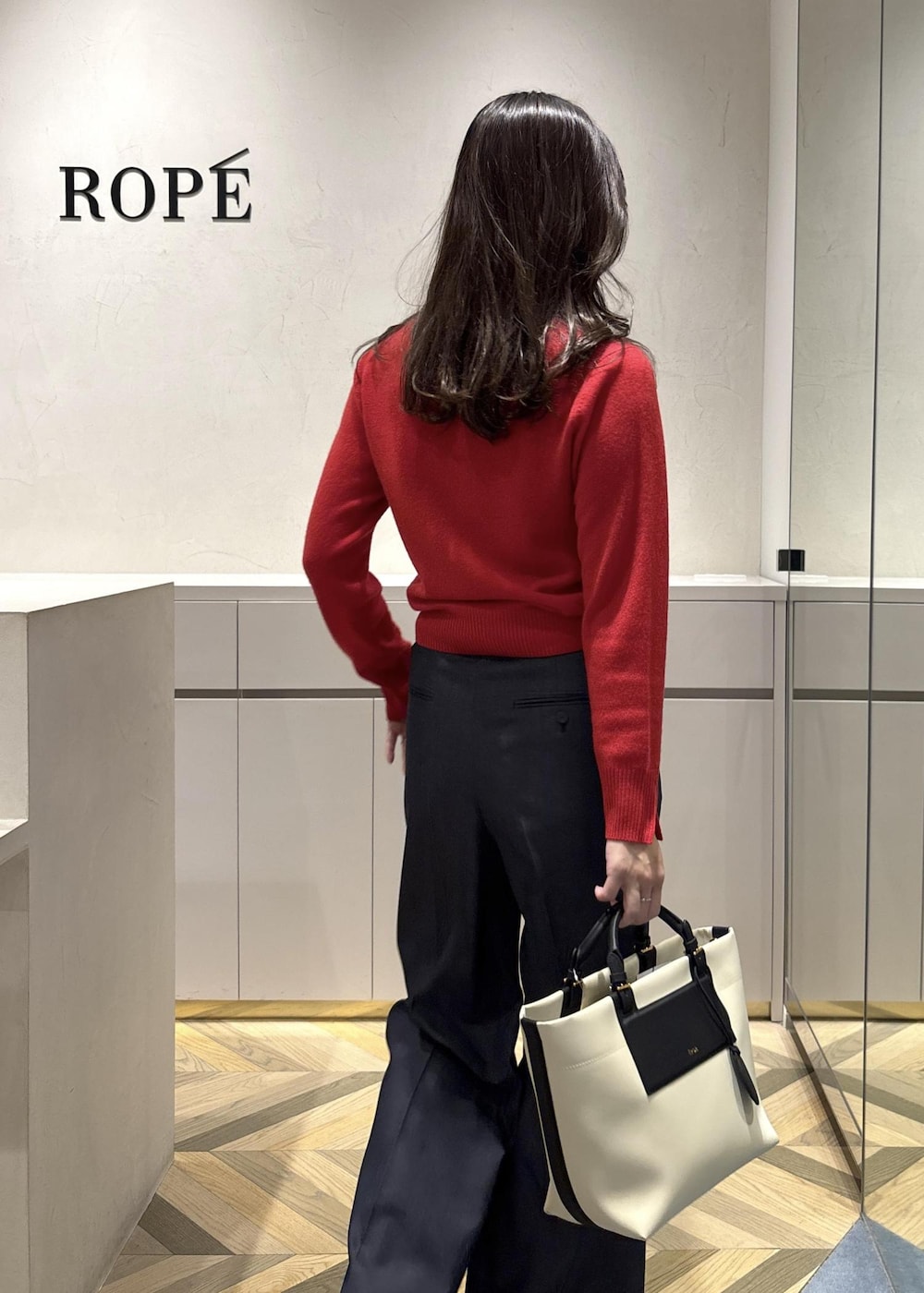 ホワイト系のトートバッグ、ブラック系のブーツ、ブルー系のその他パンツを着用したレディースの冬コーディネートの7枚目の写真