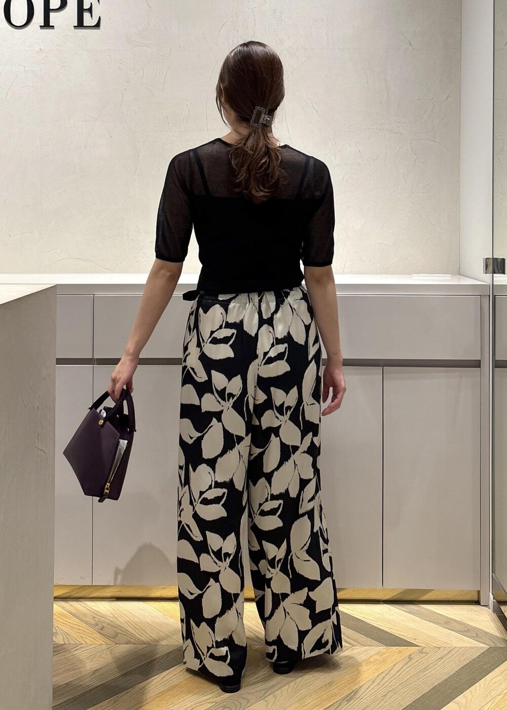 ブラック系のパンプス、ブラック系のニット/セーター、ブラック系のその他パンツを着用したレディースの夏コーディネートの3枚目の写真