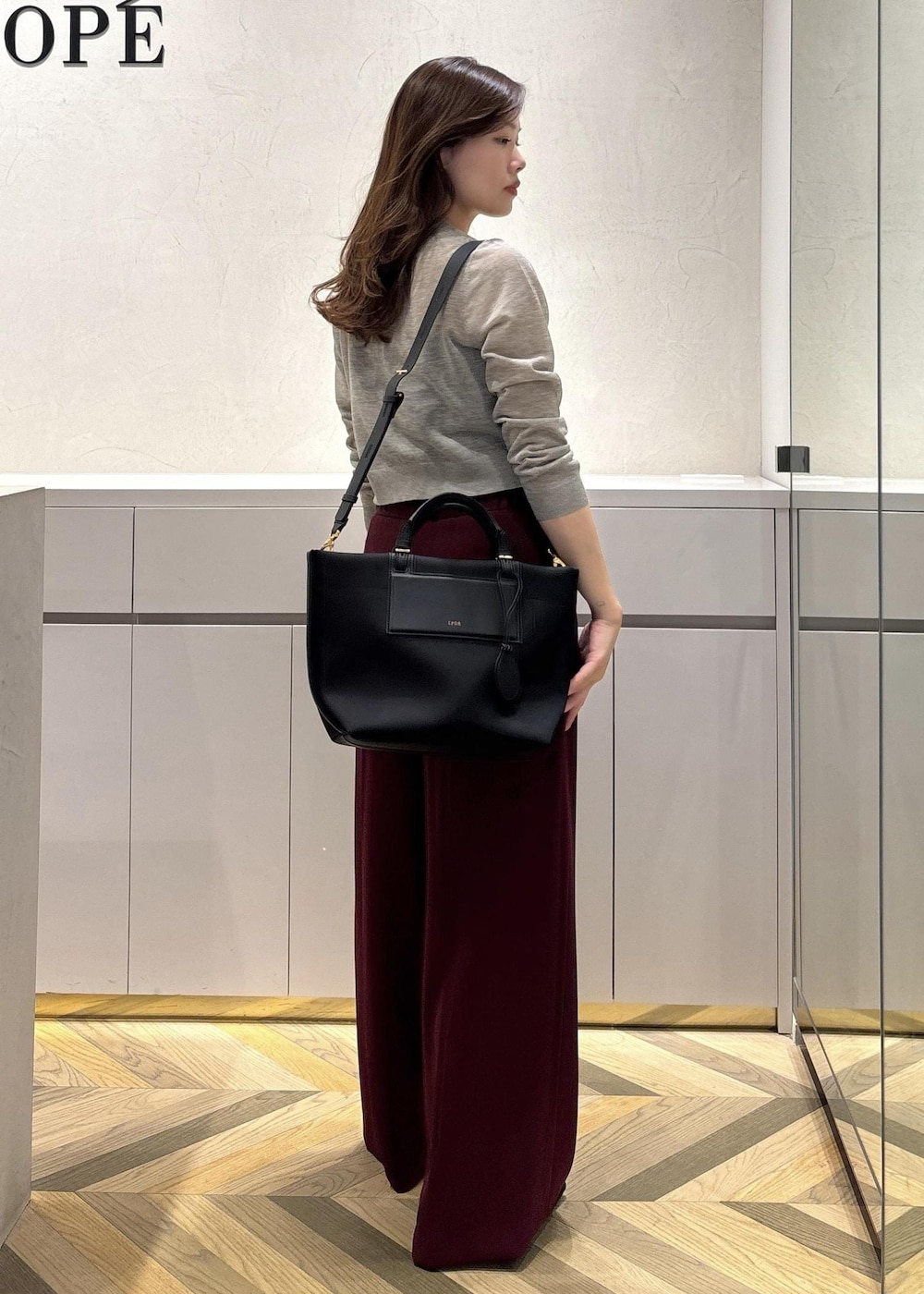 ブラック系のパンプス、レッド系のその他パンツ、ベージュ系のカーディガン/ボレロを着用したレディースの夏コーディネートの3枚目の写真