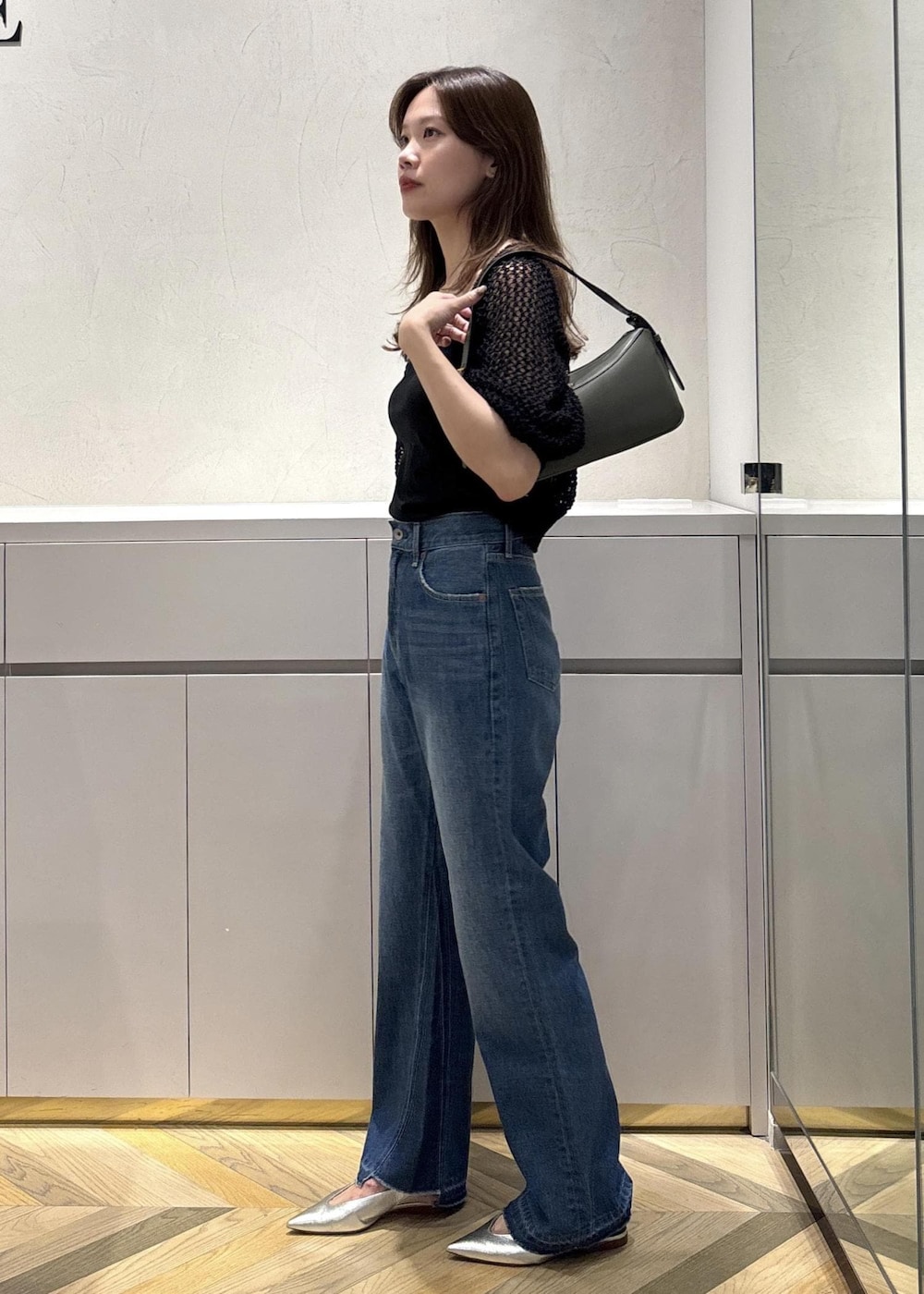 シルバー系のパンプス、グリーン系のハンドバッグ、ブラック系のキャミソールを着用したレディースの夏コーディネートの2枚目の写真