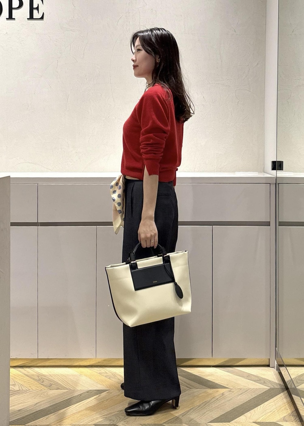 ホワイト系のトートバッグ、ブラック系のブーツ、ブルー系のその他パンツを着用したレディースの冬コーディネートの2枚目の写真