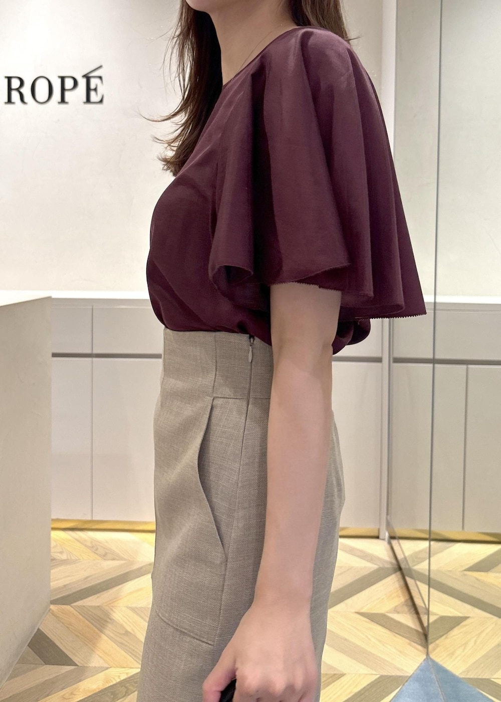 ブラック系のショルダーバッグ、ブラック系のパンプス、ベージュ系のスカートを着用したレディースの夏コーディネートの5枚目の写真