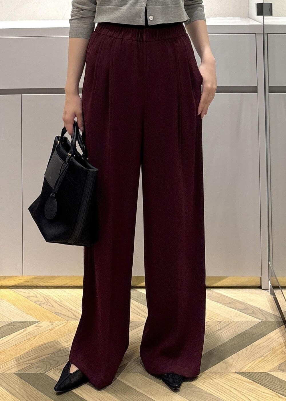 ブラック系のパンプス、レッド系のその他パンツ、ベージュ系のカーディガン/ボレロを着用したレディースの夏コーディネートの8枚目の写真