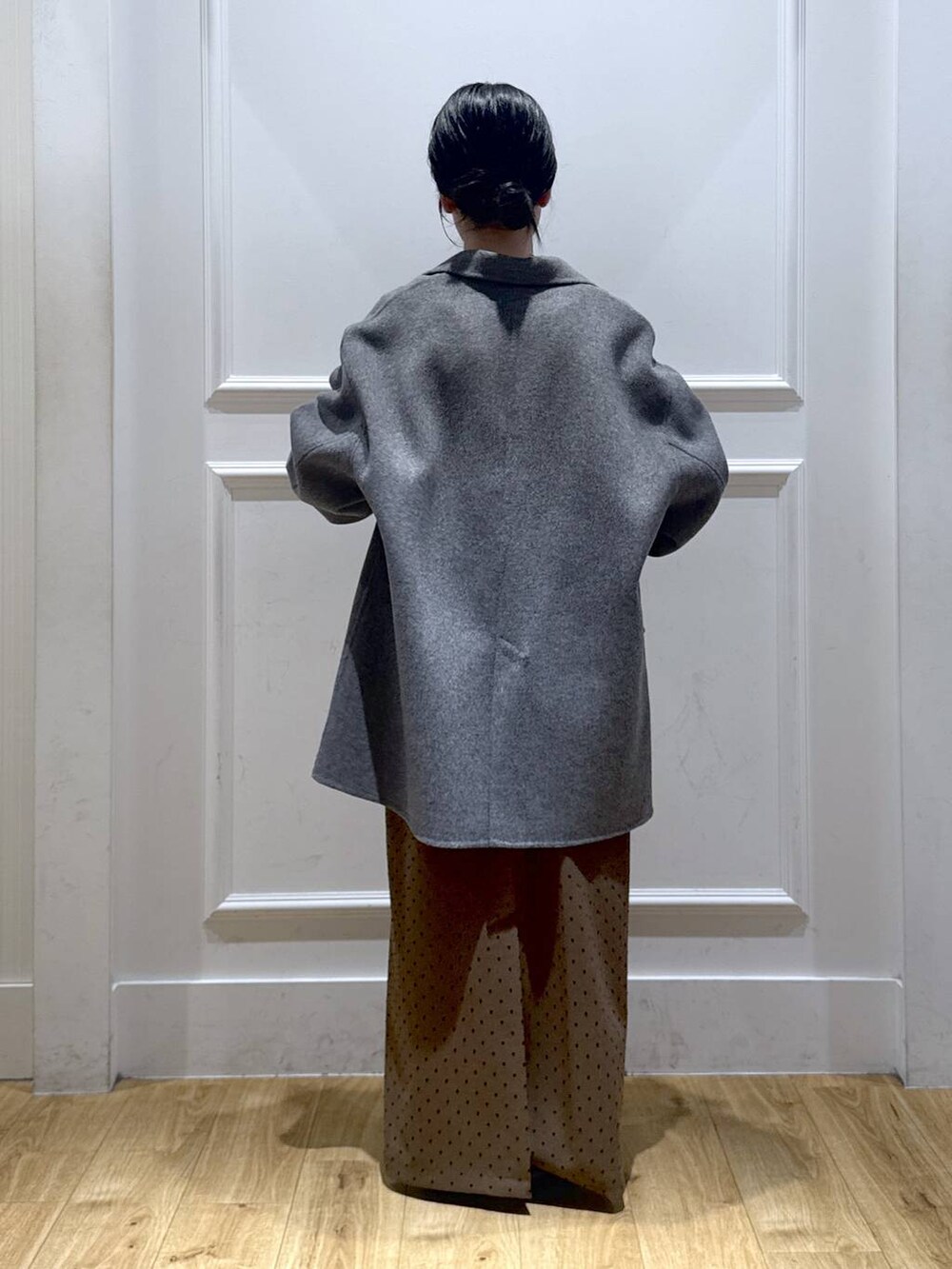 グレー系のテーラードジャケット、ブラウン系のパンプス、ブラック系のTシャツ/カットソーを着用したレディースの秋コーディネートの3枚目の写真