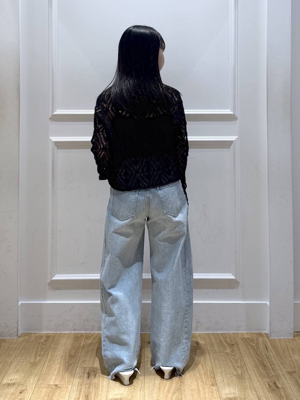 ブルー系のデニムパンツ、ブラック系のカーディガン/ボレロ、ホワイト系のサンダルを着用したレディースの春コーディネートの2枚目の写真