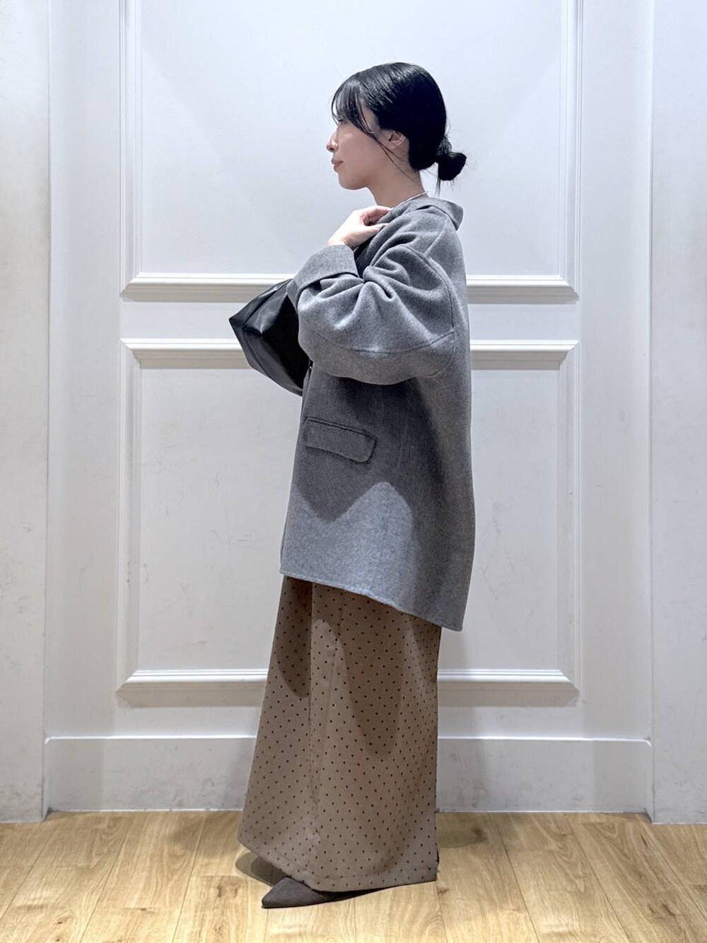 グレー系のテーラードジャケット、ブラウン系のパンプス、ブラック系のTシャツ/カットソーを着用したレディースの秋コーディネートの2枚目の写真