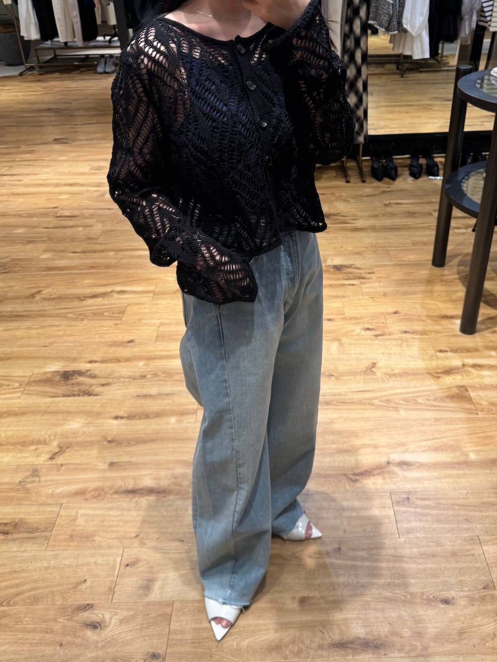 ブルー系のデニムパンツ、ブラック系のカーディガン/ボレロ、ホワイト系のサンダルを着用したレディースの春コーディネートの3枚目の写真