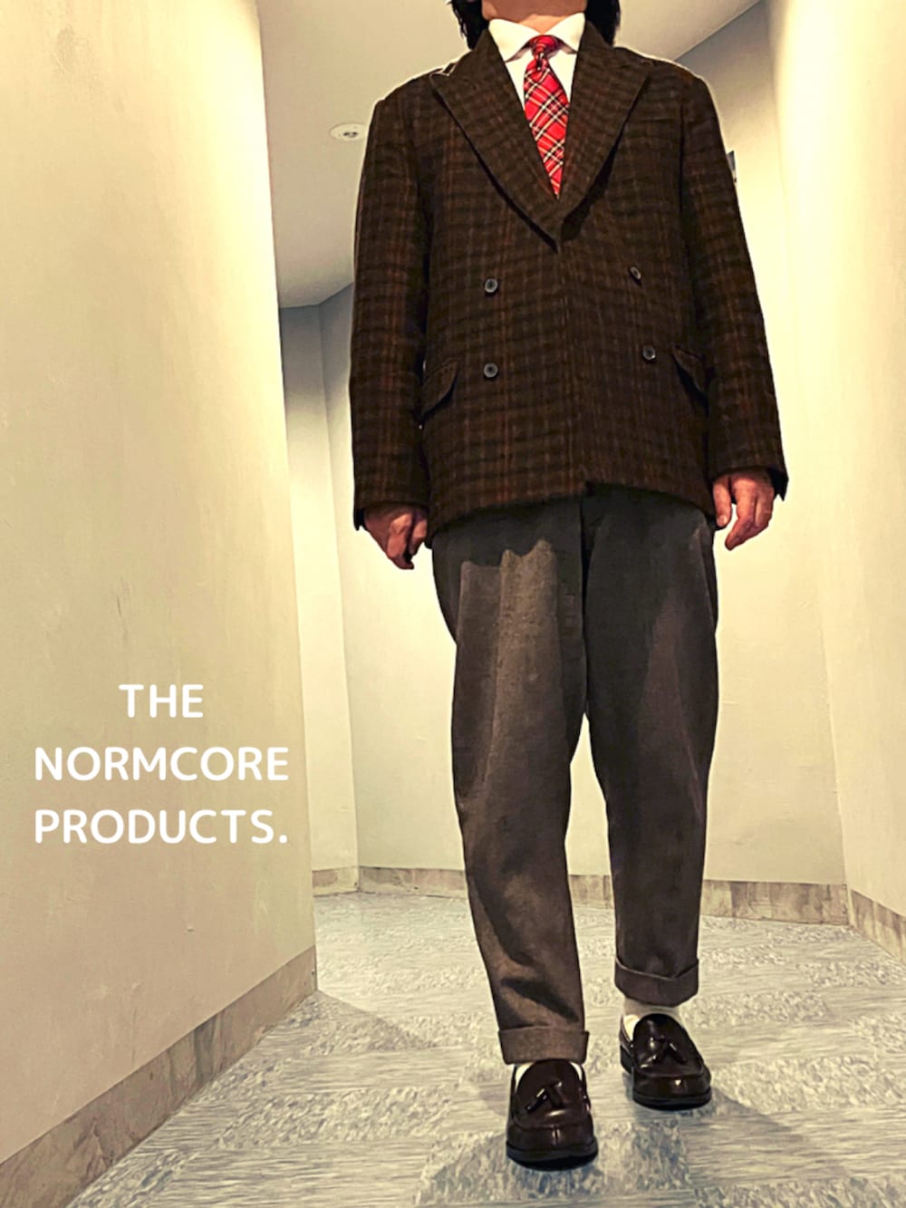 ブラウン系のテーラードジャケット、ブルー系のネクタイ、ベージュ系のスラックスを着用したメンズの冬コーディネートの3枚目の写真